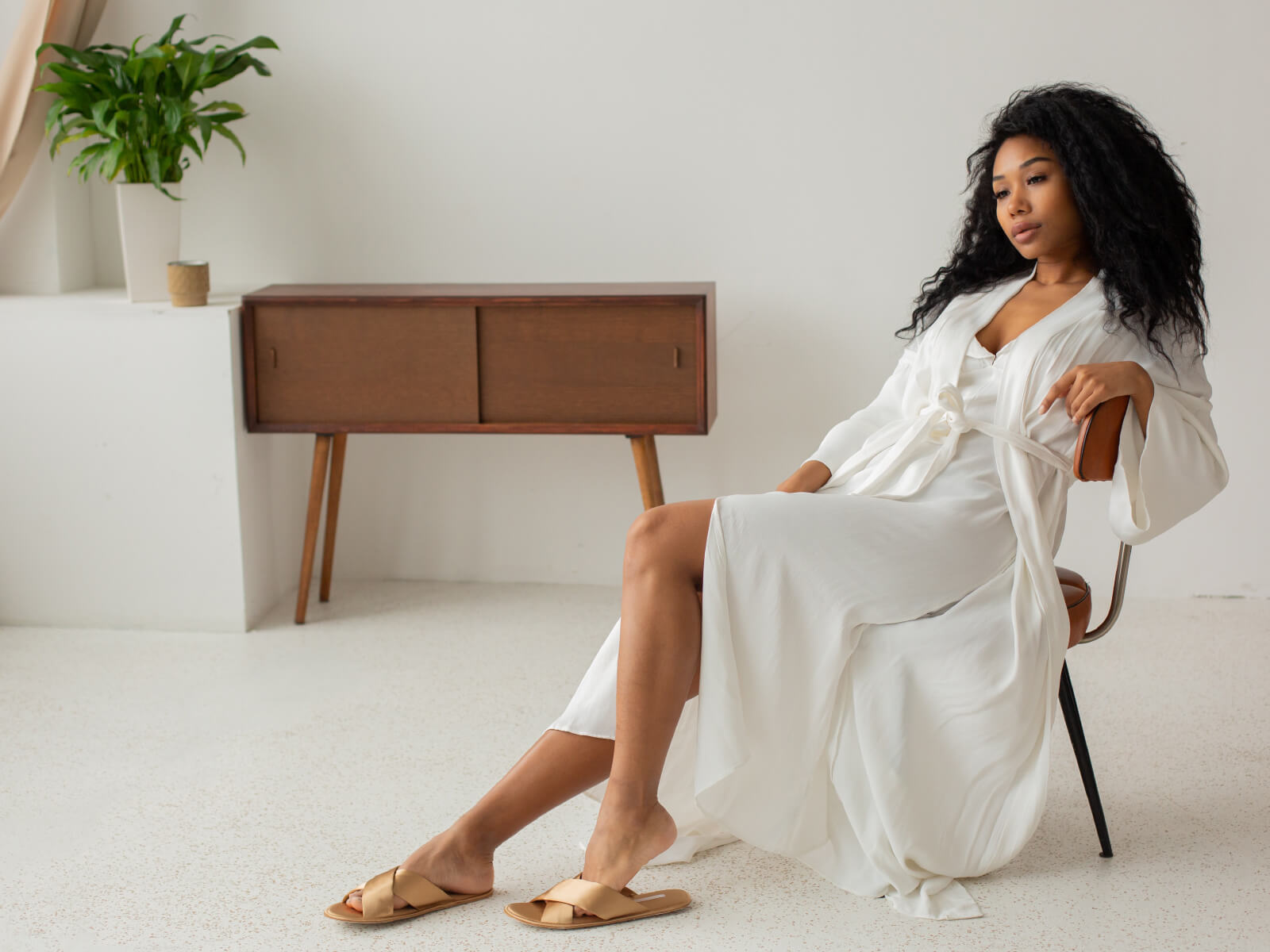 A woman in white dress sitting on chair.