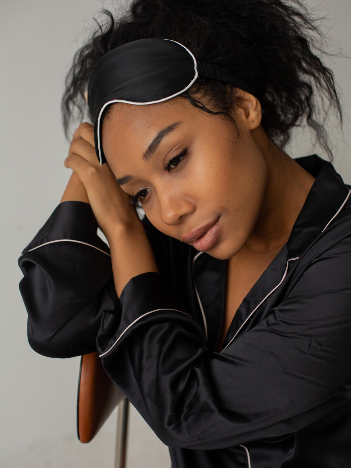 A woman in black shirt holding her head.