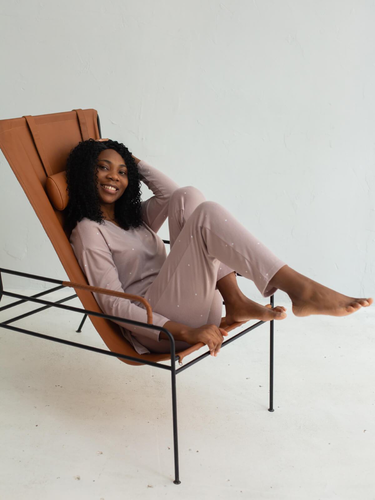 A woman sitting on top of a chair in the middle of her legs.