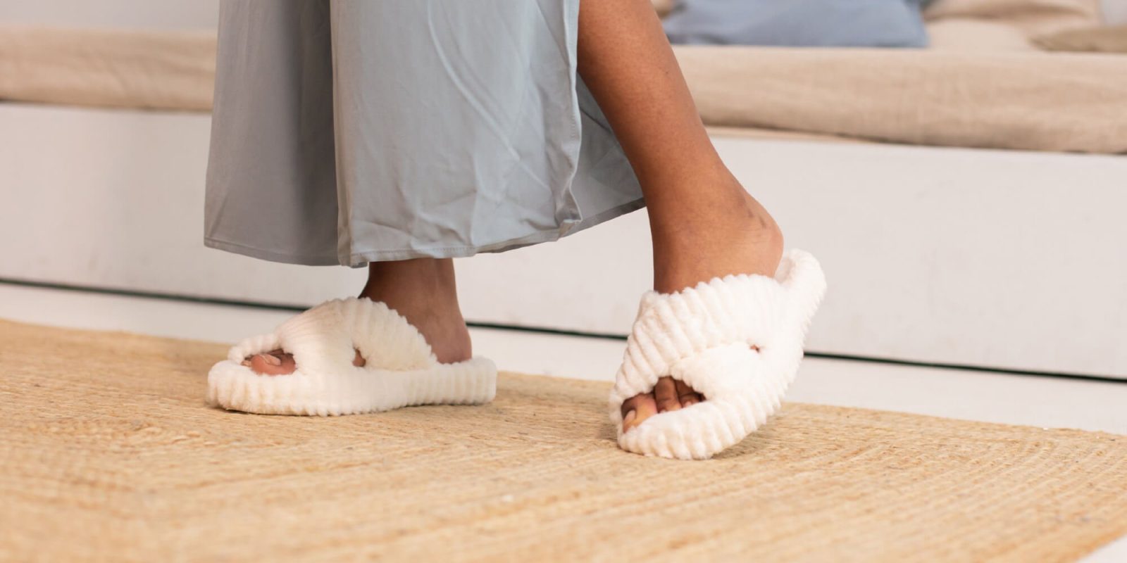 A person wearing white slippers on the floor.